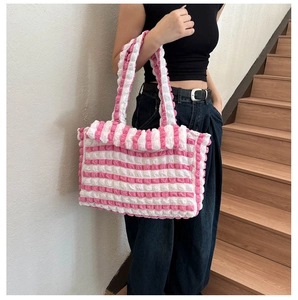 Gros plan sur la texture bouffante à rayures roses et blanches d'un grand sac cabas
