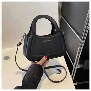Detail of black crossbody bag with round handle and gold 'FASHION & BAGS' text