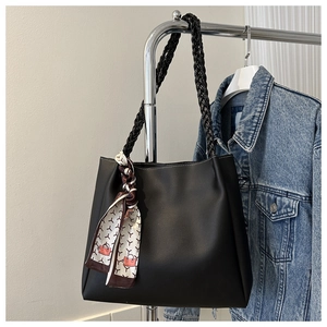 Detail of black tote bag featuring woven handle and vintage printed silk scarf decoration