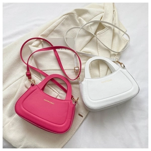 Close-up of contrast color small square bags in fuchsia and white on stylish blazer