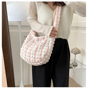 Pink and white checkered bubble bag shown on model with textured fabric and semi-moon shape