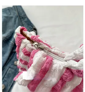 Détail du sac gaufré rose et blanc montrant de près la fermeture éclair en métal argenté fluide