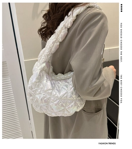 Detail of quilted iridescent white puff shoulder bag with ruched cloud strap design