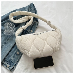 Close-up of beige quilted cloud bag with wave patterns and knotted shoulder strap