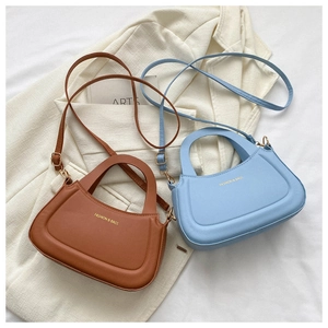 Detail of stylish shoulder bags in brown and blue with adjustable gold hardware