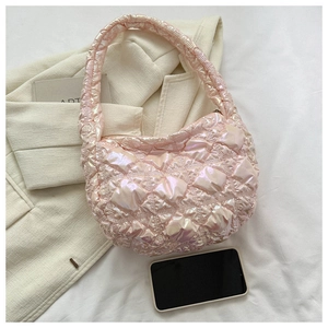 Pink quilted puffer bag on white suit with phone showing spacious interior size
