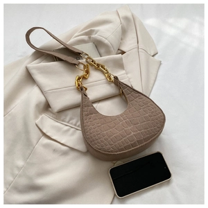 Detail der braunen Kroko-Struktur an der Halbmondtasche mit schicker goldener Kette