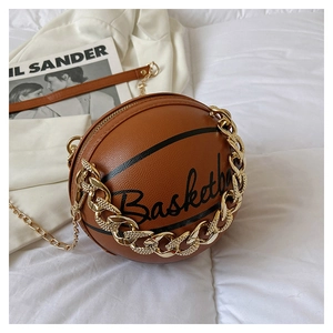 Dettaglio della borsa a tracolla a forma di basket con texture marrone e catene dorate
