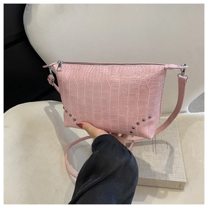 Detaillierte Makroansicht der rosa Handtasche mit Krokostruktur und silbernen Nieten