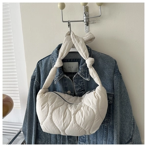 Detail of off-white quilted nylon tote with diamond stitching and knotted strap