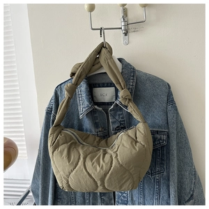 Detailed close-up of khaki quilted puffer tote with gourd stitching and knot handle