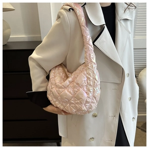 Side view of pink iridescent puffer hobo bag with quilted diamond pattern on model