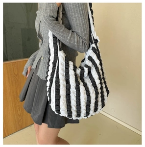 Detailed view of the bubble textured fabric and black and white stripes on tote bag