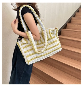 Détail du sac cabas à rayures jaunes et blanches avec texture gaufrée et moelleuse