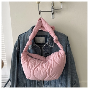 Detailed view of pink quilted puffer hobo bag with stitched texture and knotted shoulder strap