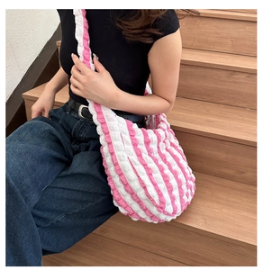 Detail of pink and white striped bubble texture fabric on a casual shoulder tote bag