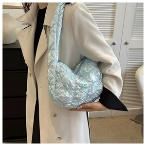 Detail of light blue quilted puffer bag with glossy finish and rhombus stitching