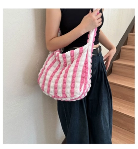 Pink and white striped shoulder bag in textured seersucker fabric shown on model