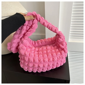 Close-up of pink ruched puffy fabric texture on a crescent shoulder bag with zipper