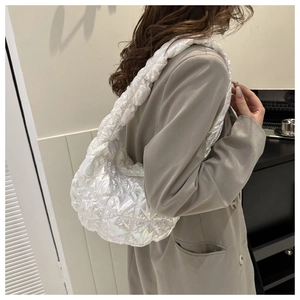 Close-up of white puffer shoulder bag featuring quilted puffy design and glossy texture