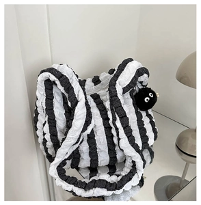 Close-up of black and white popcorn fabric tote bag with fuzzy pompom charm decoration