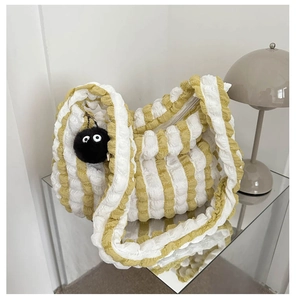 Detail showing bubble pleated texture and green striped pattern with cute plush charm