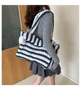 Vue détaillée du grand sac cabas à rayures noires et blanches en tissu bulle et pompon doux