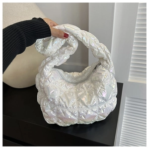 Detail of glossy quilted puffer bag with iridescent finish and knotted handle design