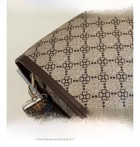 Gros plan d'un sac rétro marron en tissu trèfle avec détails en cuir et métal doré
