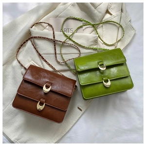Close-up of vintage mini square bags in brown and green with golden half-moon buckles