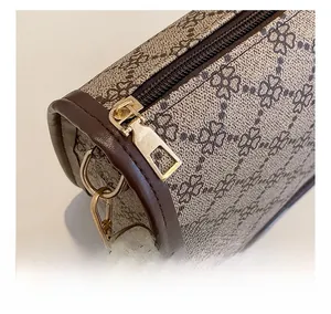Détail du sac cylindre imprimé trèfle avec fermeture éclair dorée et bandoulière