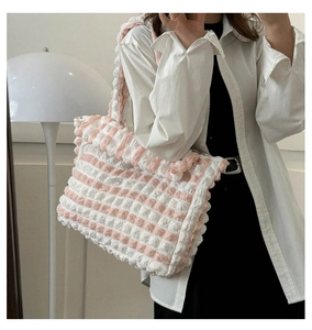 Détail du sac nuage à carreaux roses et blancs avec texture plissée sur l'épaule de femme