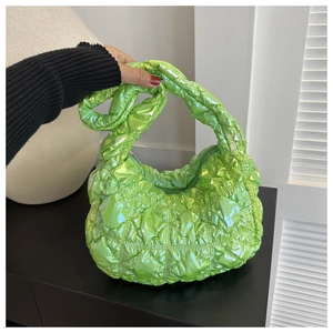 Close-up of bright green quilted puffer bag with metallic finish and grid stitching