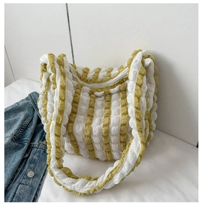 Detailed close-up of yellow and white striped bubble texture fabric shoulder bag