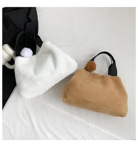 Nahaufnahme von Plüsch-Schultertaschen in Weiß und Camel mit weicher Pelztextur