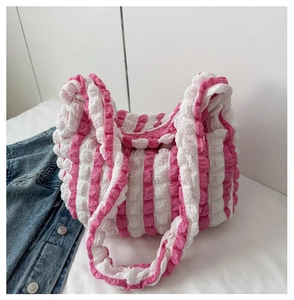 Detailed close-up of pink and white popcorn textured fabric on a stylish shoulder bag