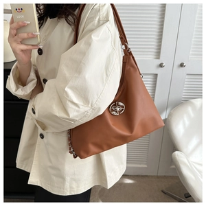 Brown PU leather hobo bag with silver metallic logo buckle shown on model's shoulder