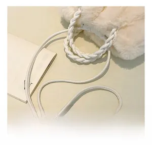 Close-up of soft white faux fur texture on a minimalist crossbody bag with woven handle