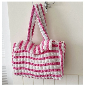 Détail de la texture gaufrée et du motif à rayures roses sur le grand sac cabas