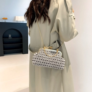 Chic black and white geometric pattern handbag with a gold chain strap and metal clasp