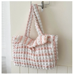 Gros plan sur le tissu à rayures rose et blanc avec texture gaufrée de ce sac cabas