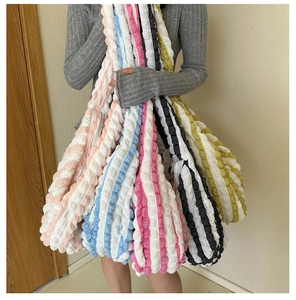 Detail of colorful bubble textured tote bags with striped patterns and soft material