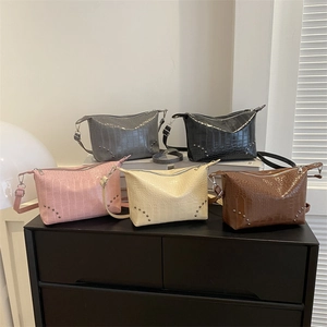 Fünf Umhängetaschen mit Krokoprägung und Nieten in Grau, Schwarz, Rosa, Weiß und Dunkelbraun