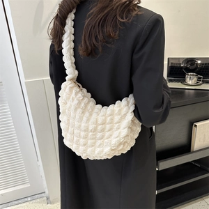 White puffy quilted cloud bag for women shown as a stylish hobo shoulder bag with crossbody strap