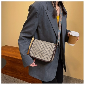 Sac bandoulière vintage en toile avec large sangle ethnique et motif floral sur modèle