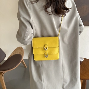 Bright yellow vintage crossbody bag with dual golden horse-bit buckles and chain strap