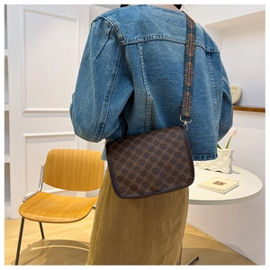 Gros plan du sac bandoulière marron rétro avec motif géométrique et large sangle brodée