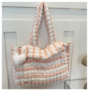 Détail du sac à rayures roses et blanches avec texture bulle et breloque cœur