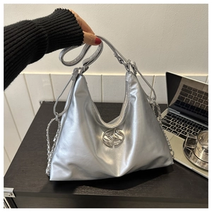Silver metallic hobo bag with chain strap shown in a lifestyle office setting