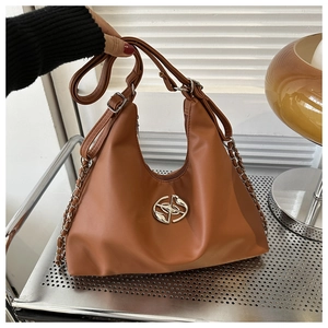 Detail view of caramel brown hobo bag with silver chain and circular metal logo